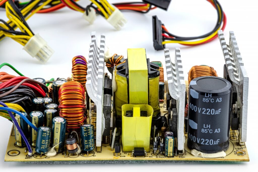 An open computer power supply at 220 volts with visible electronic components on the printed circuit