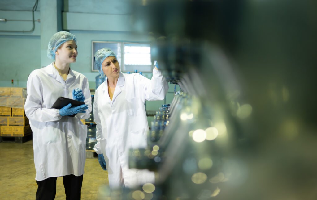 Both of female quality control workers in a drinking water factory Inspecting the quality of water