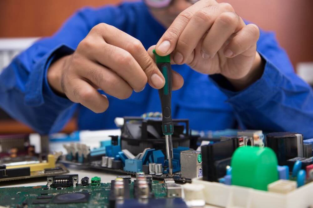 A worker testing on an electronic part in a factory