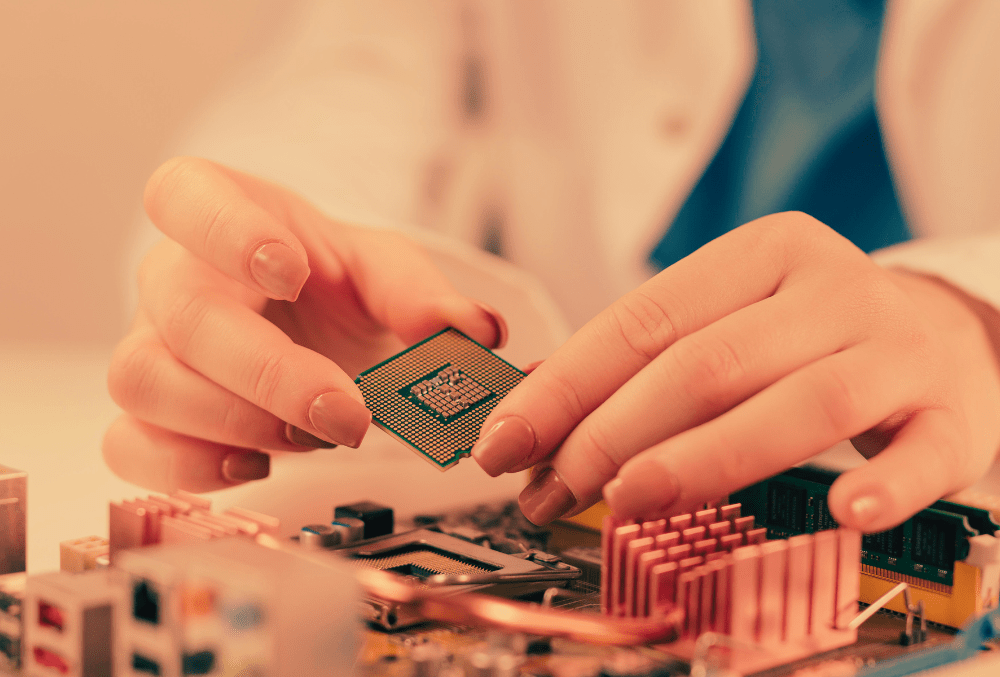 A close-up of a person carefully installing a computer processor (CPU) onto a motherboard, showcasing the precision of computer hardware assembly.