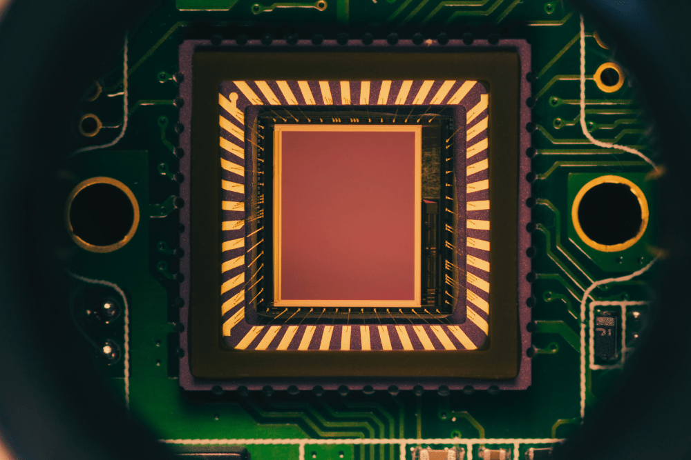 A close-up view of an electronic image sensor chip on a circuit board, showcasing intricate details of its design and structure.