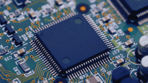 Close-up of a microchip on a printed circuit board (PCB), showcasing intricate electronic components and connections.